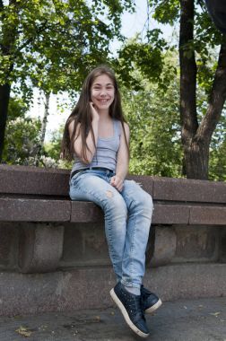 Bankta oturan genç çekici kız. Yaz park. Gülümse. Fotoğraf