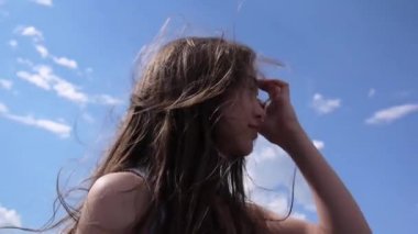 Portre saç rüzgarda ile mavi gökyüzü arka plan güzel genç kız kadar kapatın
