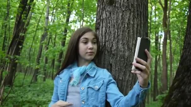 Chica tomando selfie foto smartphone en el parque en verano. Posando y sonriendo. Imágenes de vídeo . — Vídeos de Stock