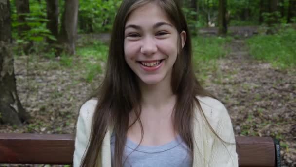 Усміхнена красива дівчина-підліток на відкритому повітрі в парку . — стокове відео