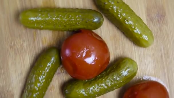 Pepinos y tomates en escabeche en una tabla de madera de corte . — Vídeos de Stock