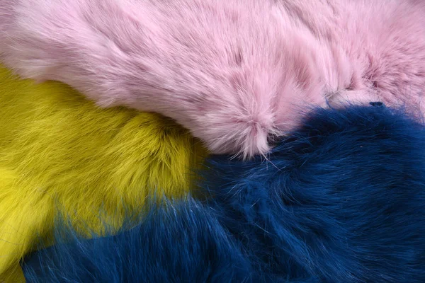 Pink blue and yellow rabbit fur background texture on the wooden table — Stock Photo, Image