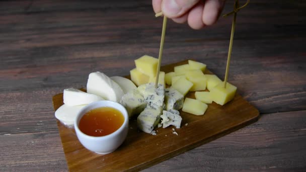 Sýrový talíř a med. Muž zkouší ruku — Stock video