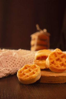 Masanın üzerinde yuvarlak waffle şeklinde bisküviler, beyaz tabak.