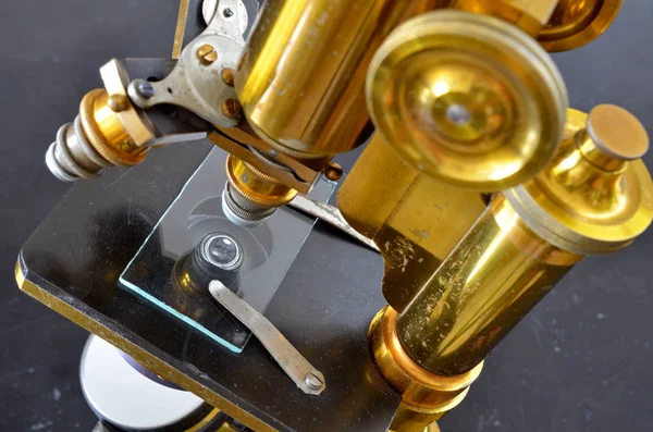 Vintage brass microscope on a dark background