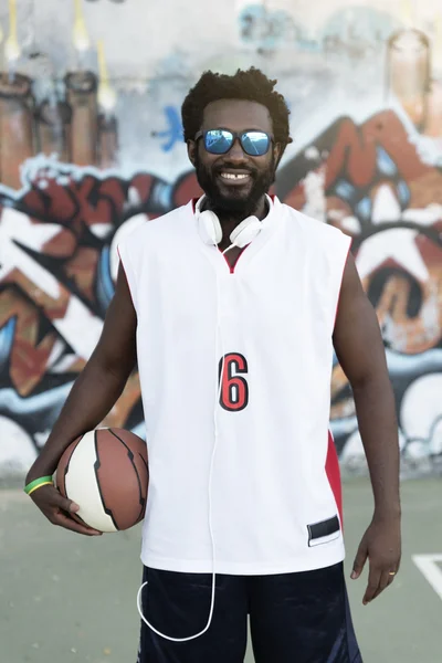 Schwarzer hält einen Basketballkorb. — Stockfoto