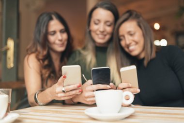 Bir akıllı telefon olarak sosyal medya izlerken arkadaşlar.