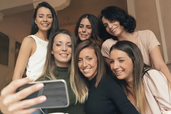 Vrienden nemen van een foto met een telefoon. — Stockfoto