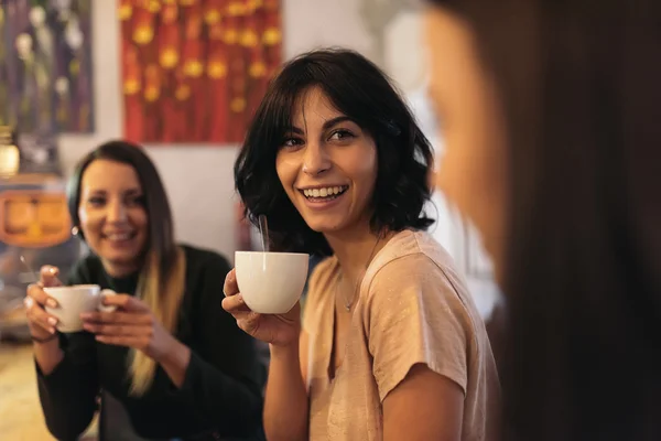 Drei schöne Frauen, die Kaffee trinken und sich unterhalten. — Stockfoto