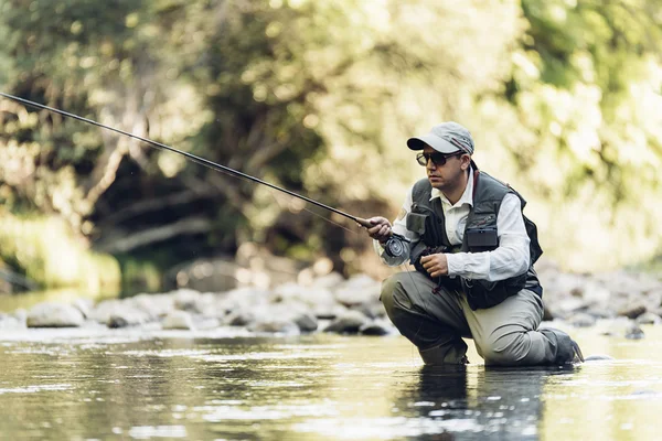 Rybak muchy za pomocą pręta flyfishing. — Zdjęcie stockowe