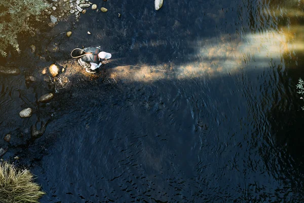 Fly fisherman using flyfishing rod.