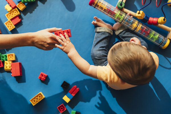 Happy baby playing with toy blocks.