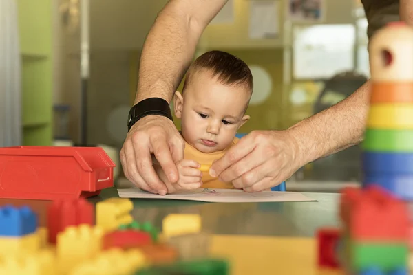 Pequeño niño y padre están dibujando en un papel . —  Fotos de Stock