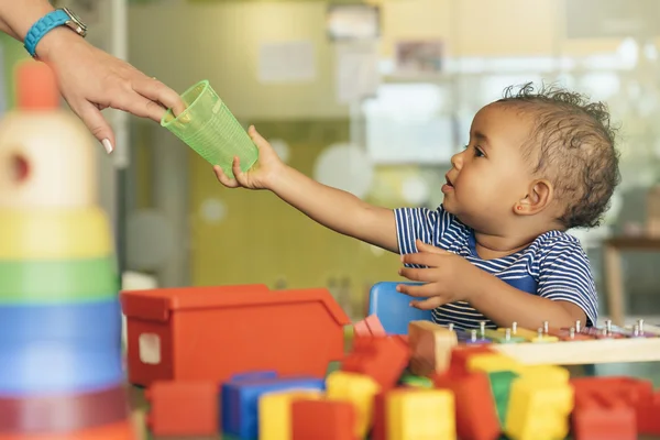 Feliz bebê bebendo água e brincando . — Fotografia de Stock