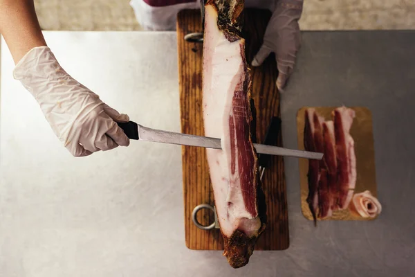 Bonita carnicera cortando jamón . — Foto de Stock