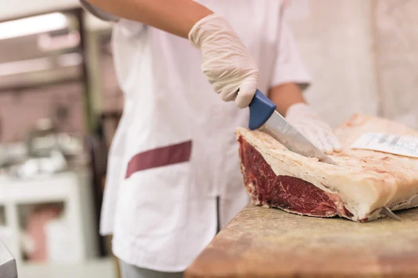 Butcher woman cutting meat. — Stock Photo, Image