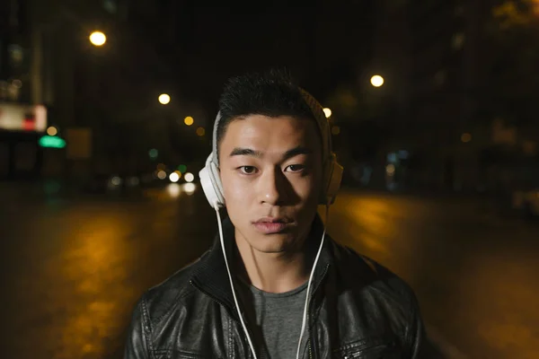 Porträt eines asiatischen jungen Mannes, der Musik hört. — Stockfoto