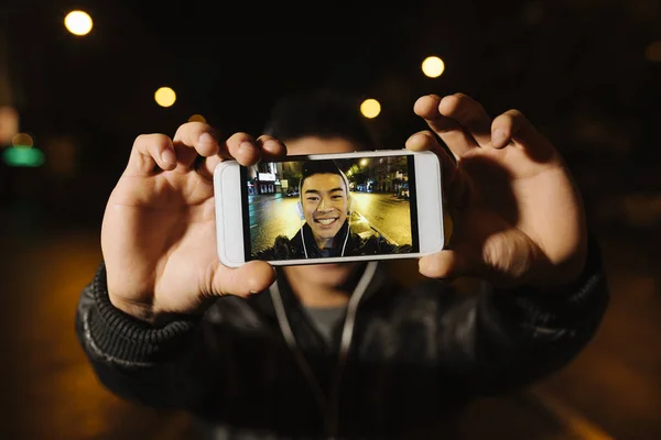 Jeune homme asiatique prendre un selfie dans la ville . — Photo