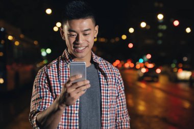 Cep telefonunu kullanarak yakışıklı genç.