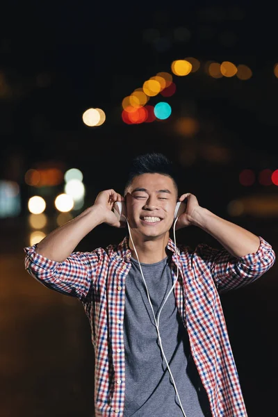 Porträt eines asiatischen jungen Mannes, der Musik hört. — Stockfoto