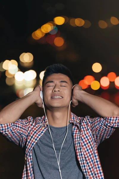 Potret dari seorang pemuda Asia mendengarkan musik . — Stok Foto