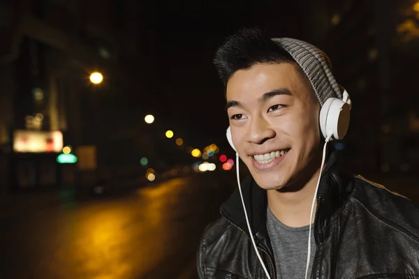 Porträt eines asiatischen jungen Mannes, der Musik hört. — Stockfoto