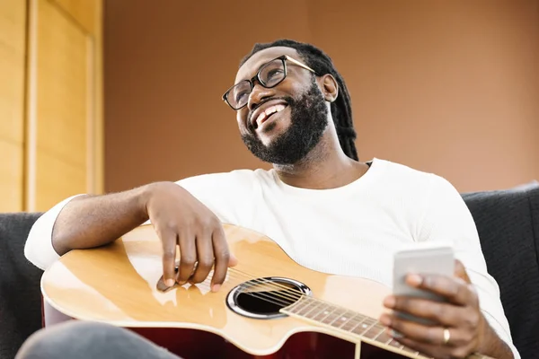 Gitarist met gitaar met behulp van mobiele. — Stockfoto