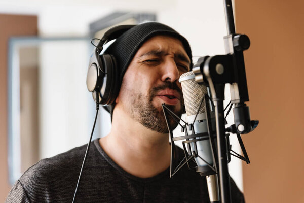 Молодой человек поет с микрофоном
.