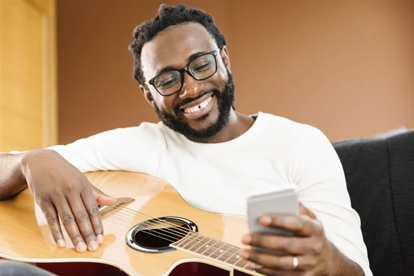 Gitarist met gitaar met behulp van mobiele. — Stockfoto