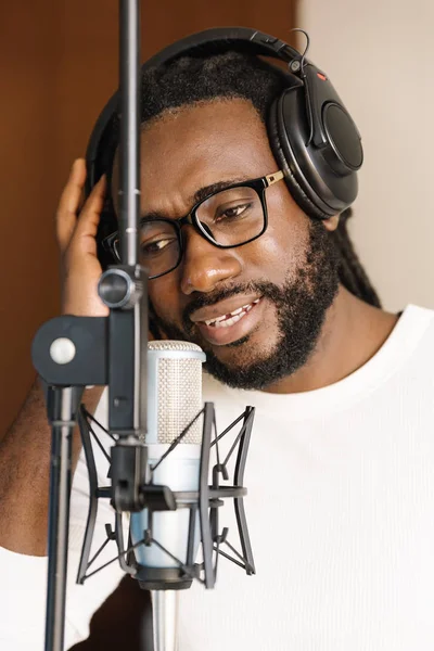 Afrikansk ung mann synger i musikkstudio . – stockfoto