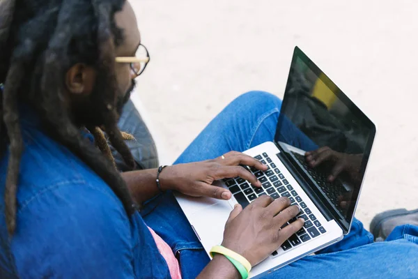 Портрет африканца, сидящего снаружи с ноутбуком . — стоковое фото