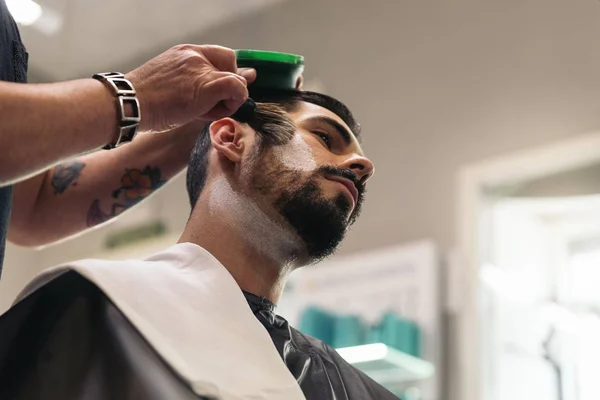 Bärtiger Mann bekommt vom Friseur eine Bartfrisur mit Rasiermesser — Stockfoto