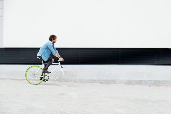 Όμορφος νεαρός άνδρας με ποδήλατο στάσιμου. — Φωτογραφία Αρχείου