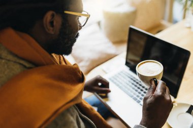 Cofee Shop'ta dizüstü bilgisayarını kullanan işadamı.