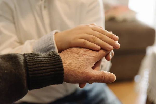 Mano di persona anziana che tiene la mano di bambino . — Foto Stock