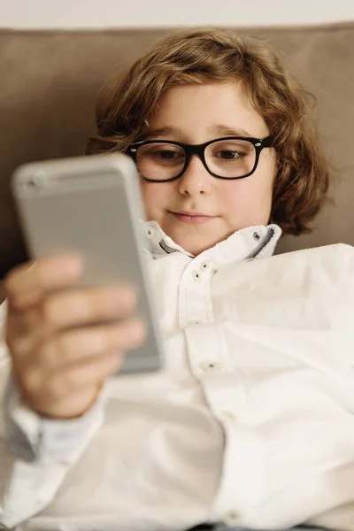 Kind jongen met behulp van zijn mobiele telefoon. — Stockfoto