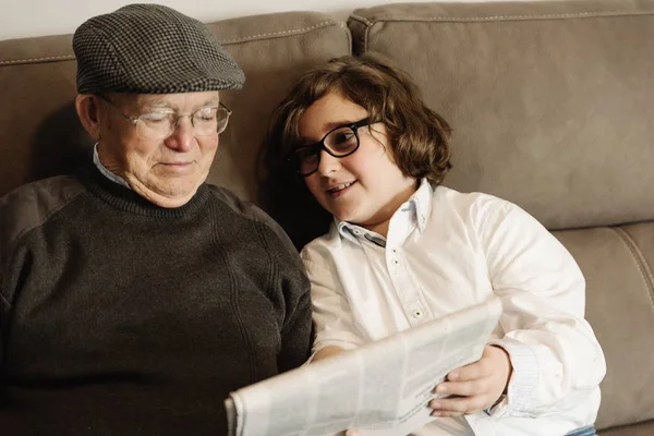 Großvater und Enkel lesen die Nachrichten. — Stockfoto