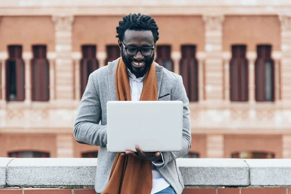 Üzletember használ a laptop, az utcán. — Stock Fotó