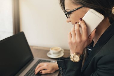 Onun laptop ve cep kafede kullanarak iş kadını.