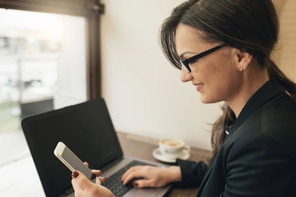 Kobieta kobieta interesu, za pomocą jego laptop i mobile w kawiarni. — Zdjęcie stockowe