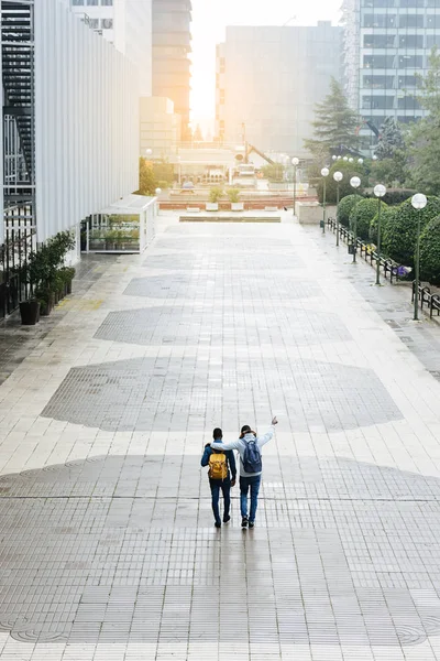 Two friends walking along the street. — Stock Photo, Image