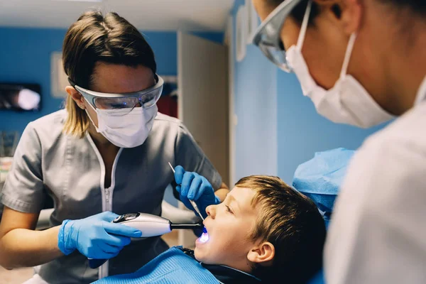 Egy beteg fiú egy fogászati beavatkozás során fogorvosok. — Stock Fotó