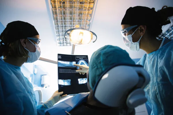 Dokter praat met haar patiënt en het onderwijzen van een radiografie. — Stockfoto