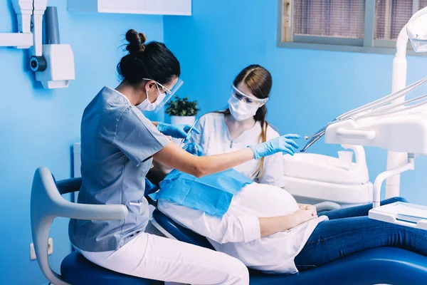 Dentisti con un paziente durante un intervento dentale . — Foto Stock