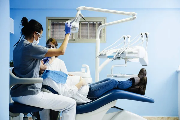 Dentisti con un paziente durante un intervento dentale . — Foto Stock