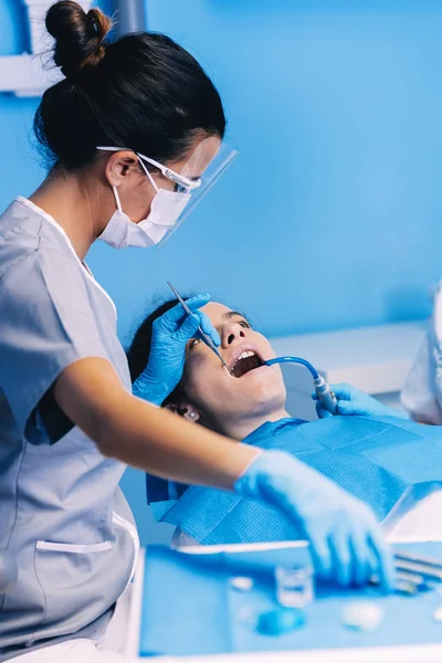Dentistas con un paciente durante una intervención dental . —  Fotos de Stock