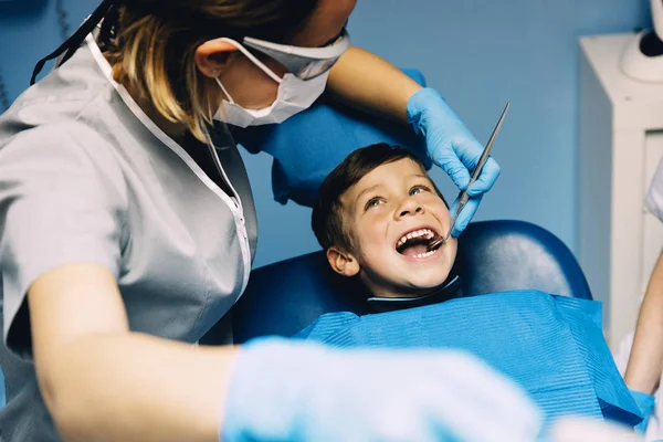 Dentistes avec un patient lors d'une intervention dentaire chez un garçon . — Photo