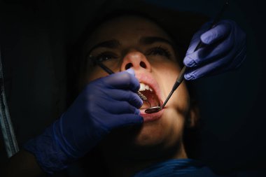 Diş hekimleri diş bir müdahale sırasında bir hastayla.