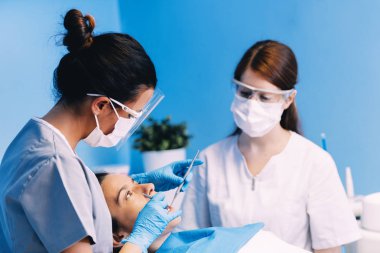 Diş hekimleri diş bir müdahale sırasında bir hastayla.
