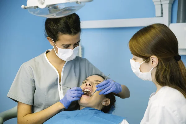 Dentistas con un paciente durante una intervención dental . — Foto de Stock